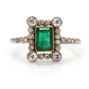 Smaragd- og diamantring af platin og guld prydet med smaragdslebet smaragd omkranset af talrige brillantslebne diamanter med ældre slibning. Str. 59,5.