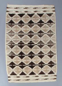 Lis Ahlmann Tæppe vævet i geometriske mønstre af uld i brune nuancer. 115 x 180.
