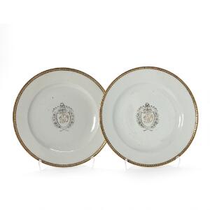 To våbentallerkener af ostindisk porcelæn, dekorerede i grisaille og guld med monogram på spejl. Kina, 18. årh. Diam. 25,5 cm. 2