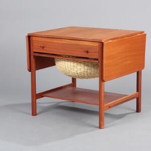 Hans J. Wegner AT 33. Sybord af teak med klapper, front med skuffe, hvorunder kurv af flet samt underliggende hylde. H. 60. L. 64118. B. 57.