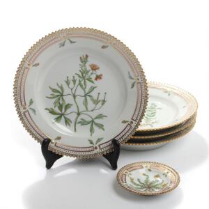 Flora Danica. Et sæt på fire sidetallerkener samt askebæger af porcelæn, Kgl. P., dekoreret i farver og guld med blomster. Nr. 3551 og 332. 5