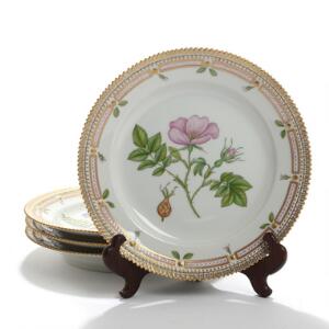 Flora Danica. Et sæt på fire frokosttallerkener af porcelæn, Kgl. P., dekorerede i farver og guld med blomster. Nr. 3550. Diam. 22. 4