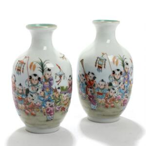 Et par kinesiske vaser af porcelæn, dekoreret med muciserende børn i farver. Stemplet. 20. årh. H. 19. 2