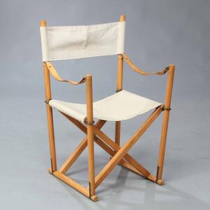 Mogens Koch Instruktørstolen. Foldestol med stel af bøg. Sæde samt ryg af lyst kanvas. Armstropper af patineret kernelæder.