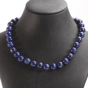 Lapis lazuli- og onyxsmykkesæt bestående af halskæde med magnetlås, prydet med perler af cabochon lapis lazuli, og et par ørestikker af sølv, prydet med onyx.