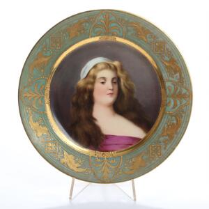 Tallerken af porcelæn, dekoreret i farver og guld med portræt af ung kvinde med løsthængende hår. Sign. Wien. Diam. 24.