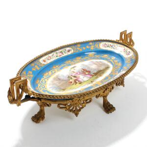Sèvres opsats af porcelæn dekoreret i blå, guld og farver med figursceneri, montering af forgyldt bronze. Anno 1872. H. 18. L. 62. B. 35.
