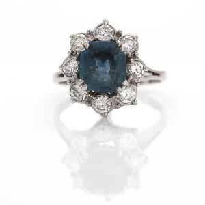 Safir- og diamantring af 18 kt. hvidguld prydet med facetslebet safir omkranset af talrige brillantslebne diamanter. Str. 53.