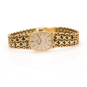 Omega Damearmbåndsur af 18 kt. guld med integreret lænke og gylden skive og visere. Manuelt optræk. Mrk. Omega de Ville. L. ca. 17 cm. Vægt 38 gr.