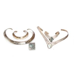 To smykkesæt af sterlingsølv bestående af halsring og armring og halsring, armring og ring prydet med abelonemusling. Diam. 12,13. 5,5 og 6 cm. Str. 53. 5