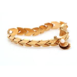 Perlearmbånd af 18 kt. guld prydet med charm med kulturperle. L. ca. 19 cm. Vægt. 14,5 g.