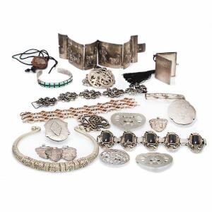Større smykkesamling af sølv og metal bestående af halsring, diverse armbånd, spænder, emblemer og vedhæng. Vægt ialt 660 gr.