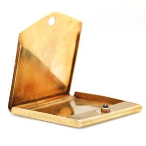 Etui til tandstikker af 14 kt. guld prydet med cabochonslebet safir. L. 5,8 x 5,2 cm. Vægt 35,5 gr.
