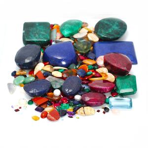 Større samling af smykkesten bestående af citriner, rubiner, smaragder, kvarts, topaser, ametyster, perler, peridoter og agat. 100