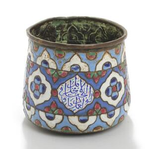 Syrisk krukke af kobber prydet med emalje i form af blomster, bladværk og inskriptioner. 18. årh. H. 15,5. Diam. 17.
