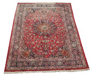 Mashhad medaljontæppe, prydet med blomster og bladværk på rød bund. Persien. 20. årh. 342 x 240.