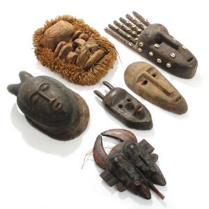 Seks afrikanske masker af udskåret og patineret træ. Bl.a Bambara. 20. årh.s første halvdel. H. 26-49. 6