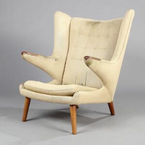 Hans J. Wegner Bamsestol. Øreklapstol med ben af eg og negle af teak, betrukket med lys uld. Udført hos AP-Stolen.