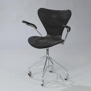 Arne Jacobsen Syveren. Kontorstol med stel af metal opsat på hjul. Sæde, ryg og armlæn betrukket med sort uld. Model 3217.