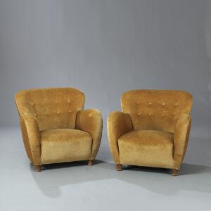 Flemming Lassen tilskrevet Et par overpolstrede lænestole med ben af bøg. Sider, sæde og dybthæftet ryg betrukket med gyldent stof. 2