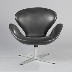 Arne Jacobsen Svanen. Lænestol på helstøbt profileret firpasfod af aluminium. Skalformet sæde betrukket med patineret sort skind.