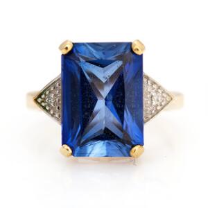 Safir- og diamantring af 9 kt. guld prydet med facetslebet safir flankeret af enkeltslebne diamanter. Str. 49.
