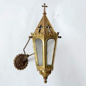 Væglampet af forgyldt messingblik, med holder til ét stearinlys. Gotisk form, 20. årh.s begyndelse. Lampet H. 45.