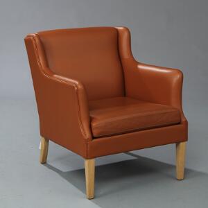 Orla Mølgaard-Nielsen Jade-stol opsat på tilspidsende ben af eg. Sider, sæde samt ryg betrukket med lyst brunt farvet skind.