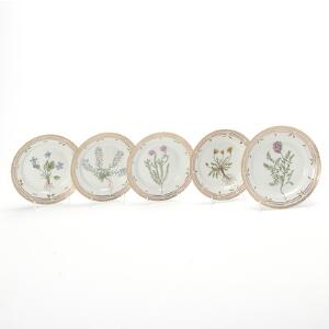 Flora Danica fire sidetallerkener og en frokosttallerken af porcelæn, dekorerede i guld og farver med blomster. 3573, 3550. Royal Copenhagen. 5