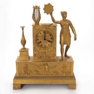 Fransk Charles X kaminur af forgyldt bronze, prydet med stående danserinde med trampolin. Ca. 1840. H. 35. B. 26. D. 9.