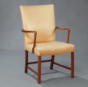 Armstol med stel af bejdset bøg. Sæde samt ryg betrukket med lys naturskind. Udført hos Fritz Hansen.