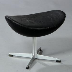 Arne Jacobsen Skammel til Ægget, opsat på firpasfod og profileret stamme af aluminium. Sæde betrukket med sort skind. Model 3127.