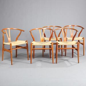 Hans J. Wegner Y-stolen. Et sæt på fem armstole af kirsebærtræ, sæde af papirflet, samt tre tilhørende hynder af sort skind. 5