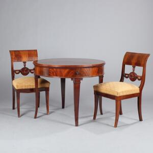 To senempire stole af mahogni, prydet med skæringer, samt rundt sofabord af mahogni, sarg med fire skuffer. 19. årh. Bord H. 71. Diam. 89. 3