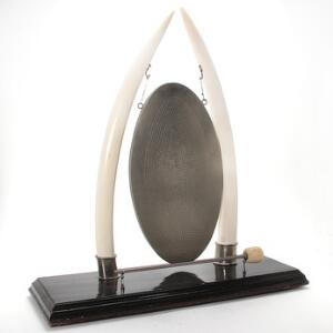 Gongon af ædeltræ monteret med to elefantstødtænder hvor i mellem plade af hamret metal. H. 8578 cm