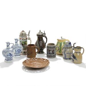 En samling krus, lågkrus og kander af saltglaseret stentøj, porcelæn og fajance samt Søholm fajancefad. 19.-20. årh. H. 12-24. Diam. 23,5. 10