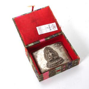Cigaret etui af sølv prydet med Medicin buddha og sky, bagsiden med inskription. Vægt 149 gr. H. 8,5 cm. L. 10 cm.