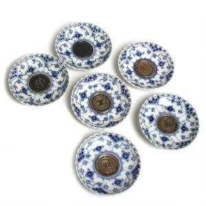 Musselmalet helblonde. Seks lysmanchetter af porcelæn, Kgl. P. nr. 1009, med indsatte jubilæumsmønter. Diam. 9. 6