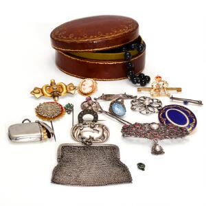 Smykkesamling af metal og sølv bestående af diverse brocher, nåle, taske og tændstikholder i læderæske.