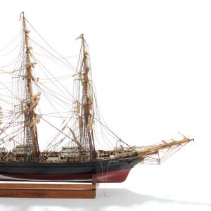 Coriolands. Skibsmodel af den tremastede engelske fuldrigger, af bemalet og poleret træ, stående på træhylde med plexiglas. 20. årh.
