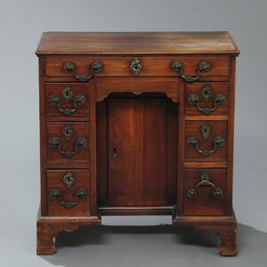 George III kneehole desk af mahogni, front med skuffe, underdel med dør og flankeret af tre små skuffer. England, 18. årh.s slutning. H. 72. B. 69. D. 43.