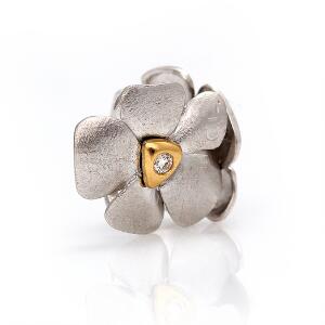 Charlotte Lynggaard Diamantlås af 14 kt. guld og hvidguld i form af blomst prydet med to brillantslebne diamanter på i alt ca. 0.10 ct. Diam. ca. 1,6 cm.