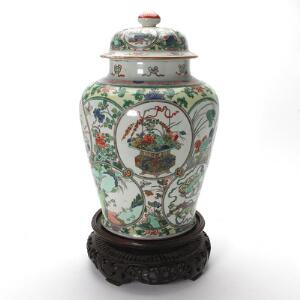 Stor kinesisk famille verte lågkrukke af porcelæn, dekorerede i farver med ornamentik, kostbare ting, dyr, landskaber og blomster. 19. årh. H. 54 cm.