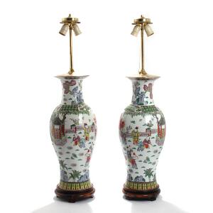 Et par bordlamper af porcelæn rigt dekoreret med landskaber og figurscenerier, baser af udskåret hardwood. 20. årh.s begyndelse. H. 113. 2