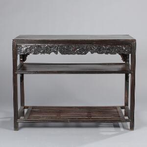 Kinesisk fritstående konsolbord af mørkbejdset hardwood, med to hylder, prydet med drueklaser og bladværk. 19. årh. H. 76. L. 99. B. 48.