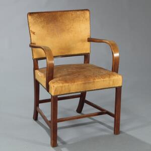 Ole Wanscher Armstol med stel af mahogni. Sæde og ryg betrukket med patineret messingsømbeslået skind. Udført hos Fritz Hansen.