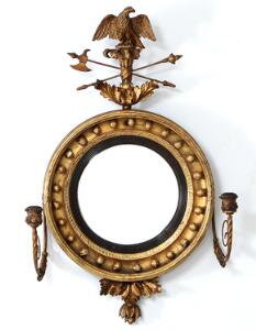 Regency butlers mirror af forgyldt træ med konveks spejlglas og to svungne lysarme af metal. England, 19. årh.s begyndelse. H. 81. B. 55.