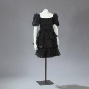 Sort fest kjole med sløjfe og pufærmer med similisten. Str. 36. L. ca. 85 cm.