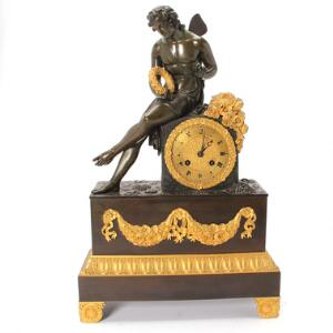 Fransk Charles X kaminur af forgyldt og patineret bronze, urhus med siddende yngling. Paris, ca. 1830. H. 48. B. 31. D. 12.