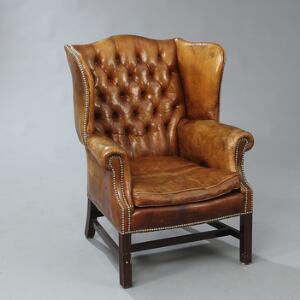 Engelsk Wing Chair betrukket med brunt skind. George III form, 20. årh.